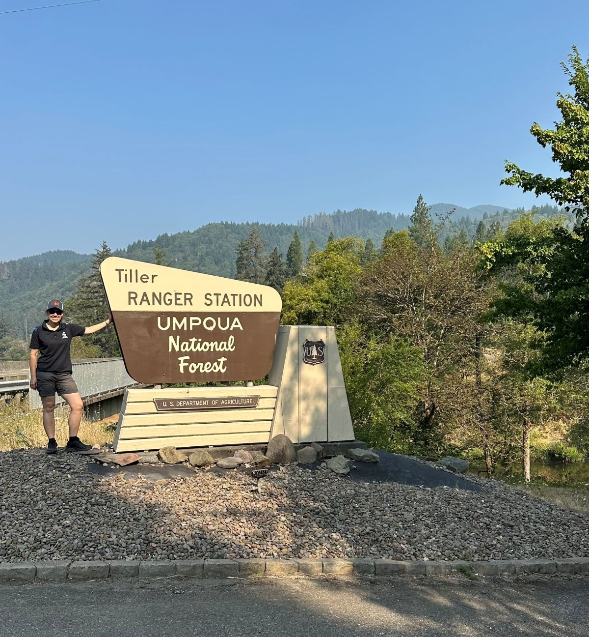 Erika next to the Tiller Ranger Station at Umpqua National Forest sign