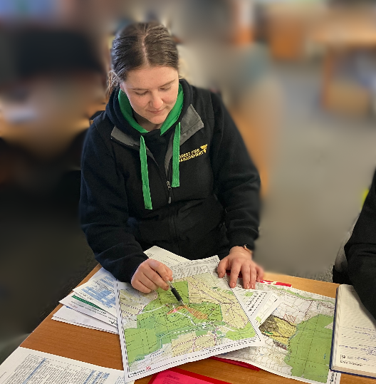 Danielle Johnston Fire Support Officer at desk looking at a map