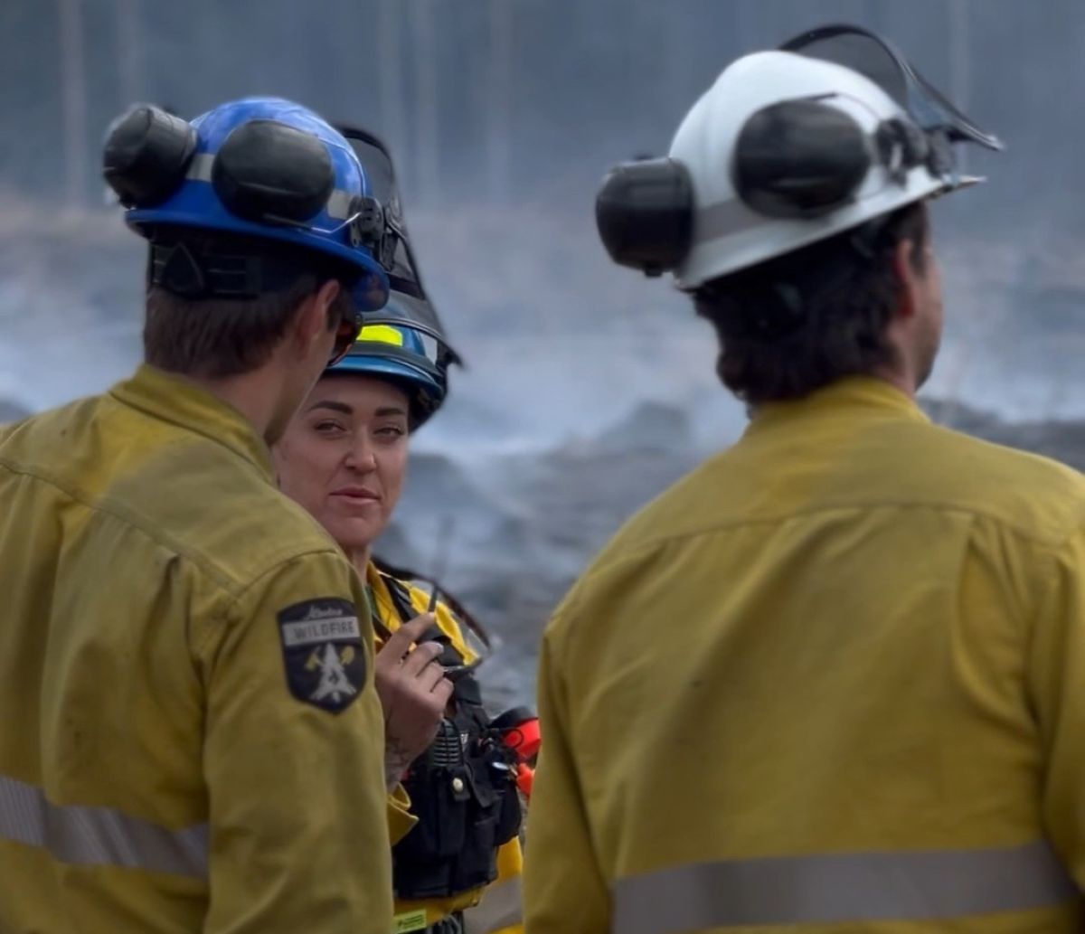Kellie in the field talking to two Canadians firefighters