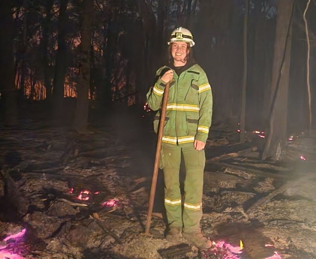 Emily wearing her green overalls and working in a bushfire at night