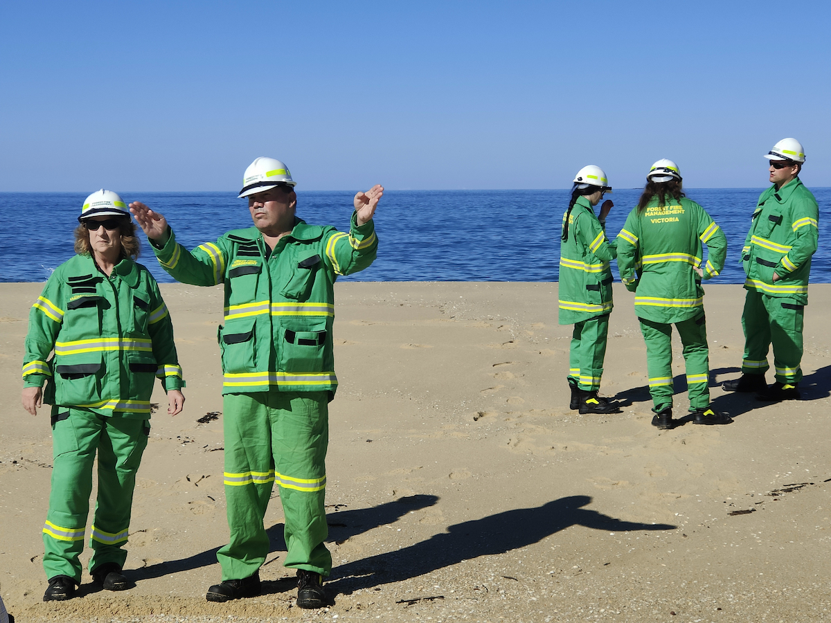 Emergency workers assessing storm impact on a beach.