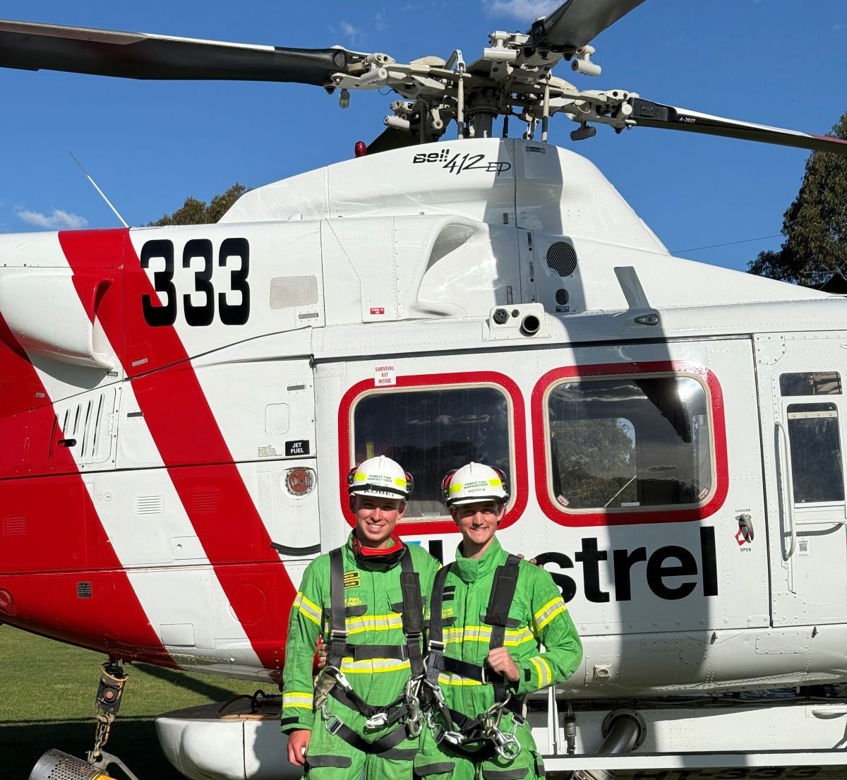 Kobei and a colleague with a helicopter in the background