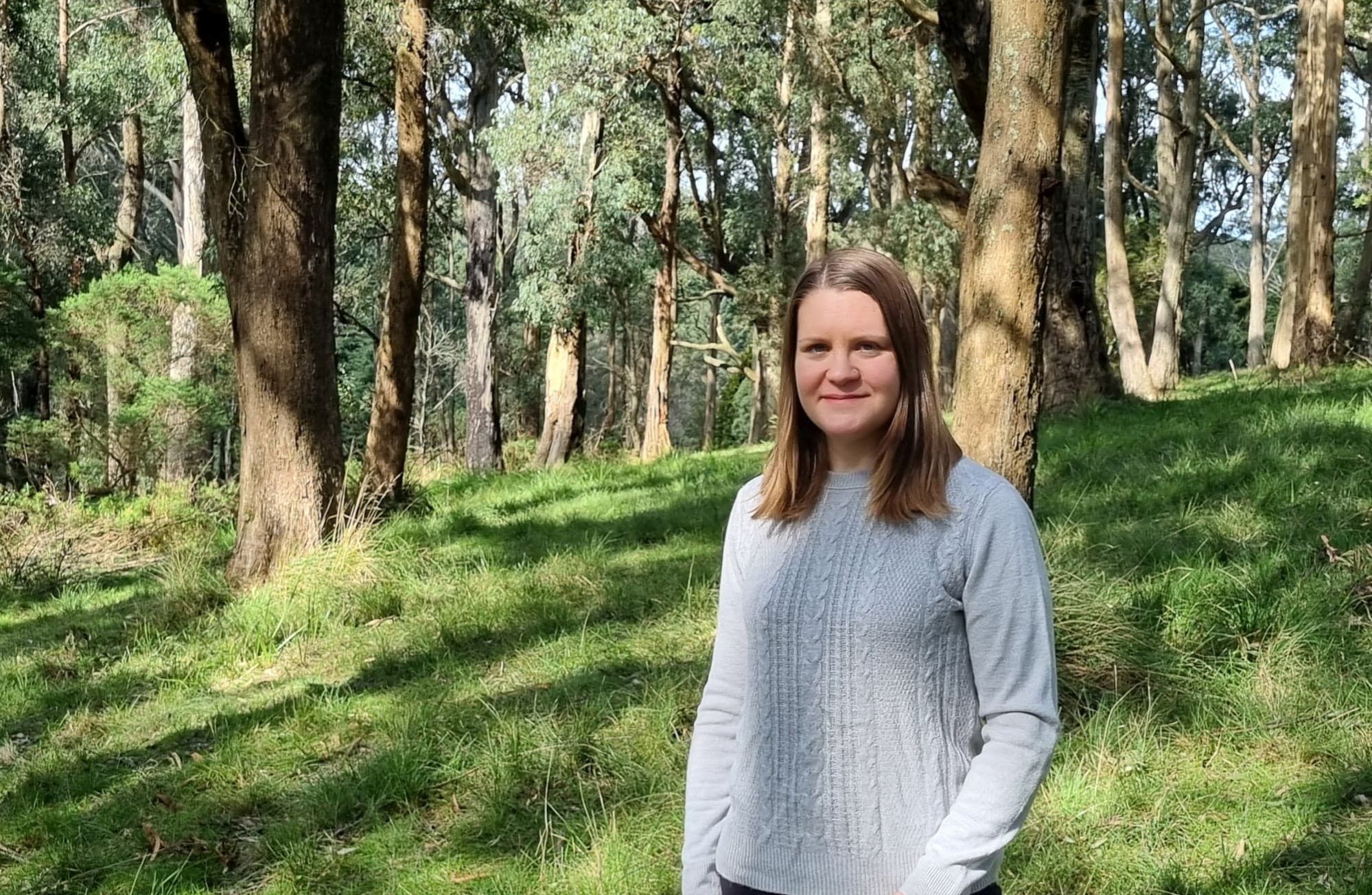 Dr Kerryn McTaggart standing in a forest.