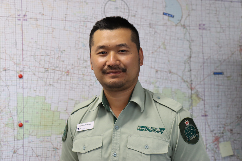 Headshot of Kawtha Thaw Pay. He's wearing a pale green button-up shirt and standing against a pale background