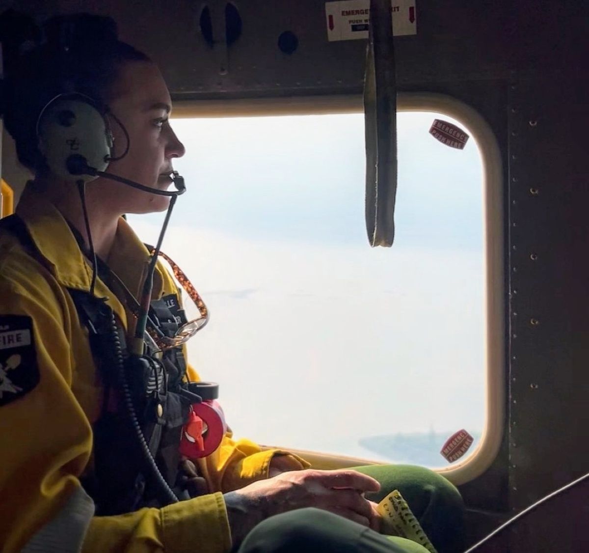 Kellie inside a helicopter wearing her yellow uniform in Canada