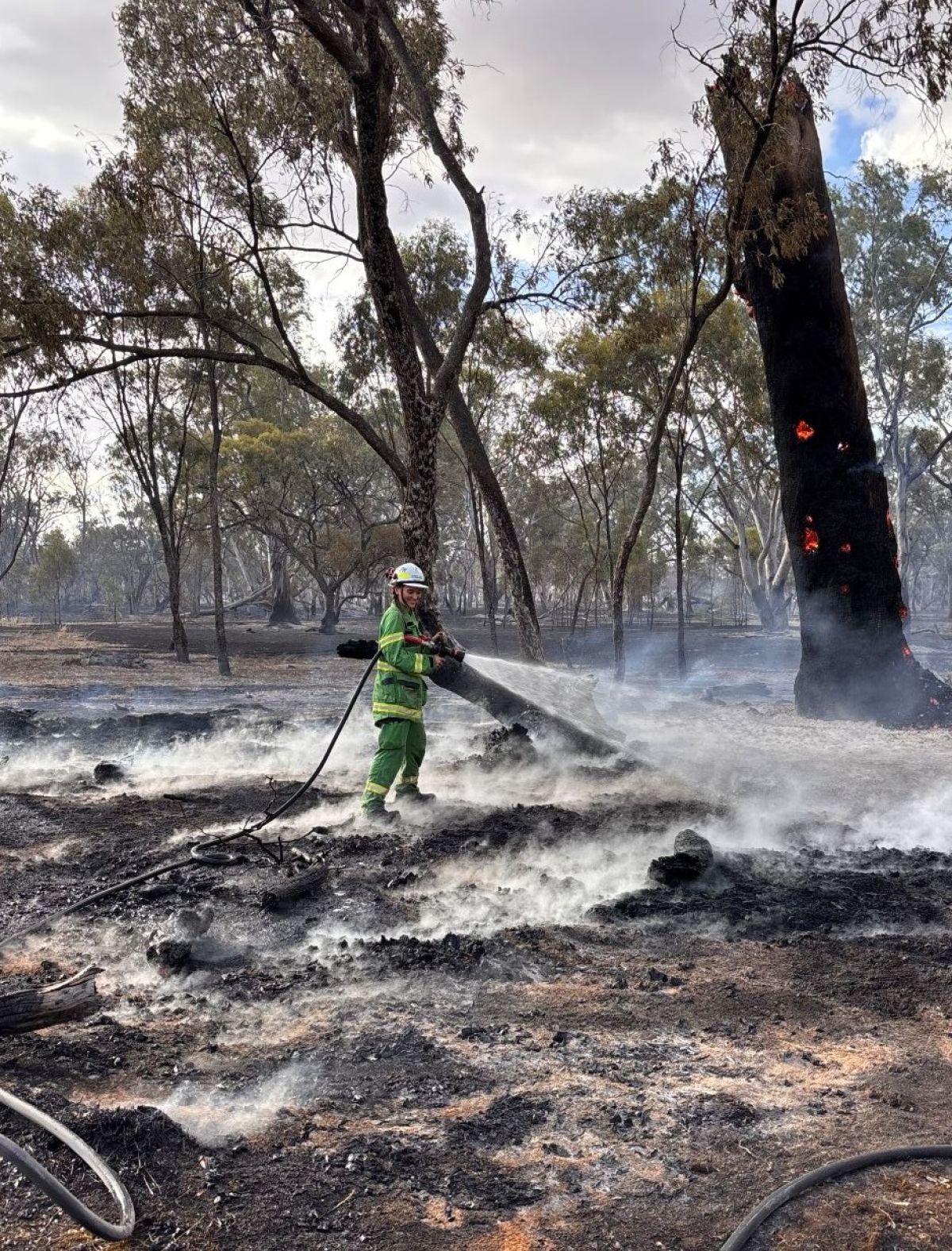 Angela using a hose during a fire