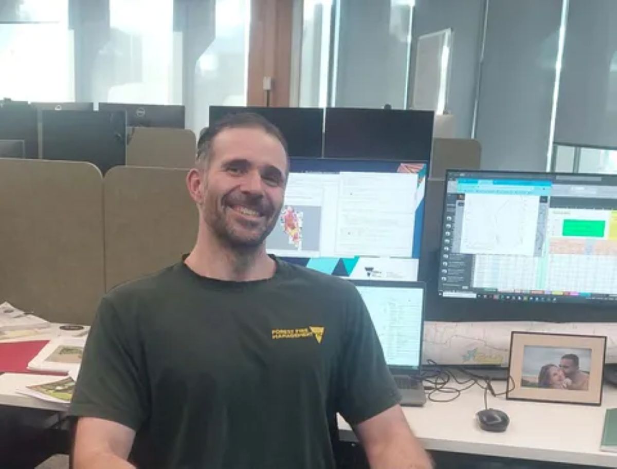 Phin in his officewearing a FFMVic green t-shirt