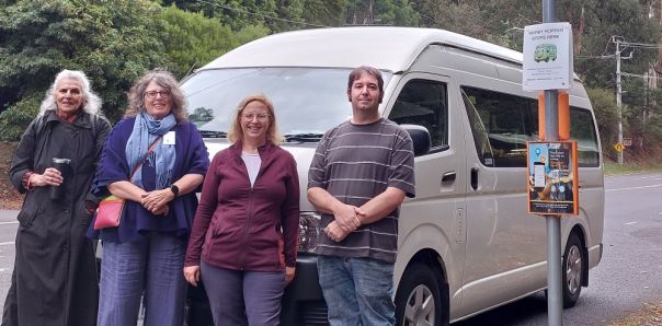 People standing in front of mini bus