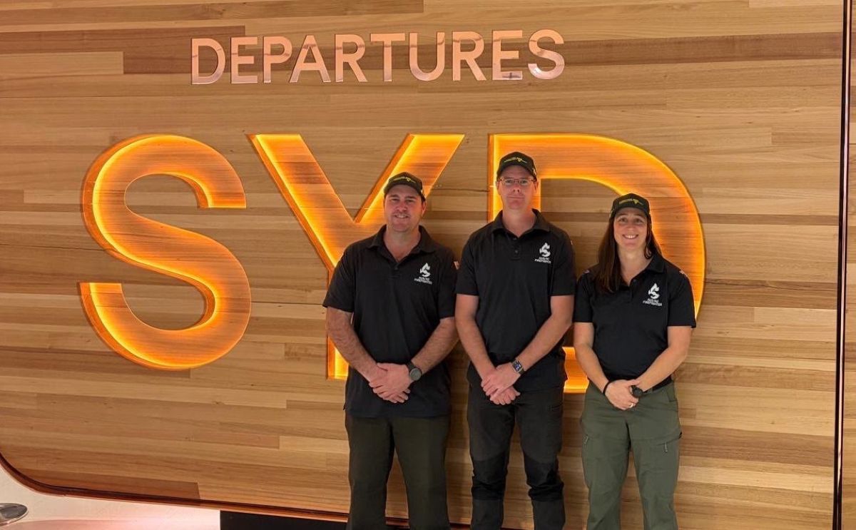 Beth with two more FFMVic in front of the Sydney airport sign